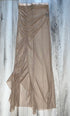 A sheer, taupe-colored skirt with ruffle and ruched embellishments at the waist, displayed against a wooden background.