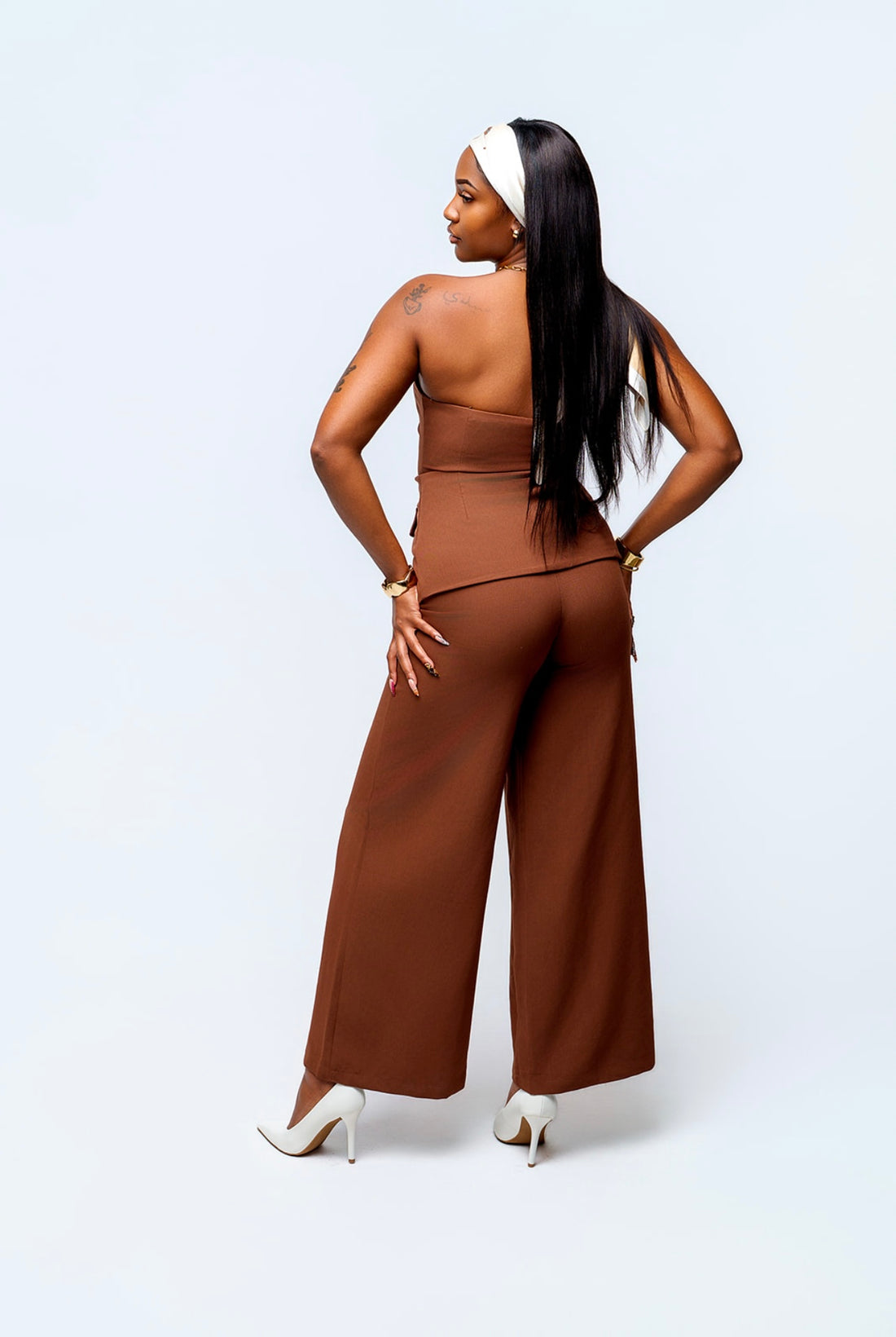 Woman wearing a brown jumpsuit on a white background
