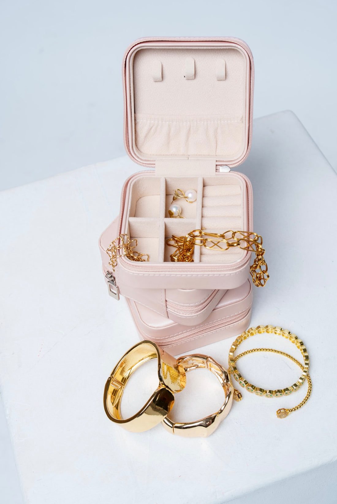 Open compact jewelry box with jewelry in it